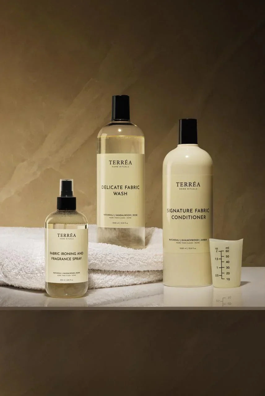 Set of Terrea fabric care products including a spray bottle, liquid soap, and conditioner on a neutral background.