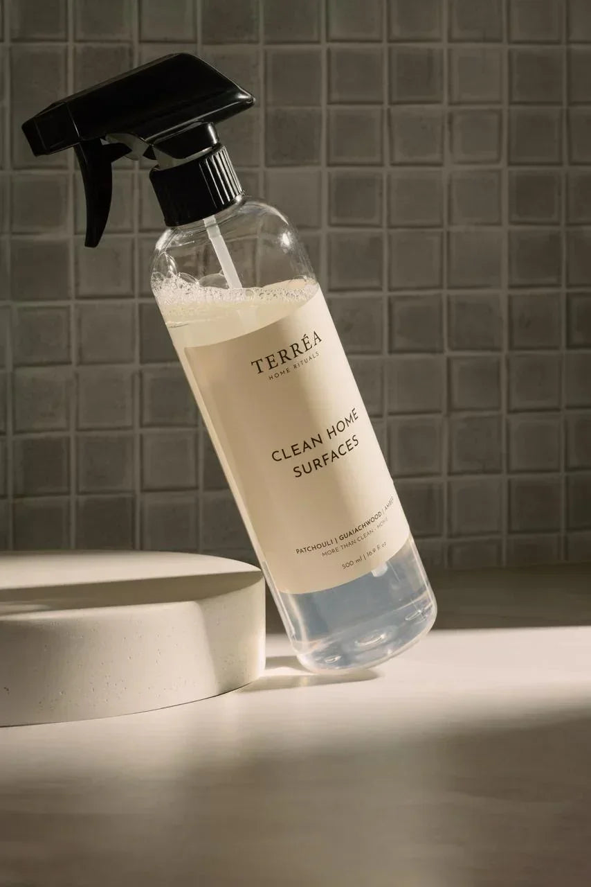 Bottle of Terrea Clean Home Surfaces cleaner on a countertop with a tiled wall background