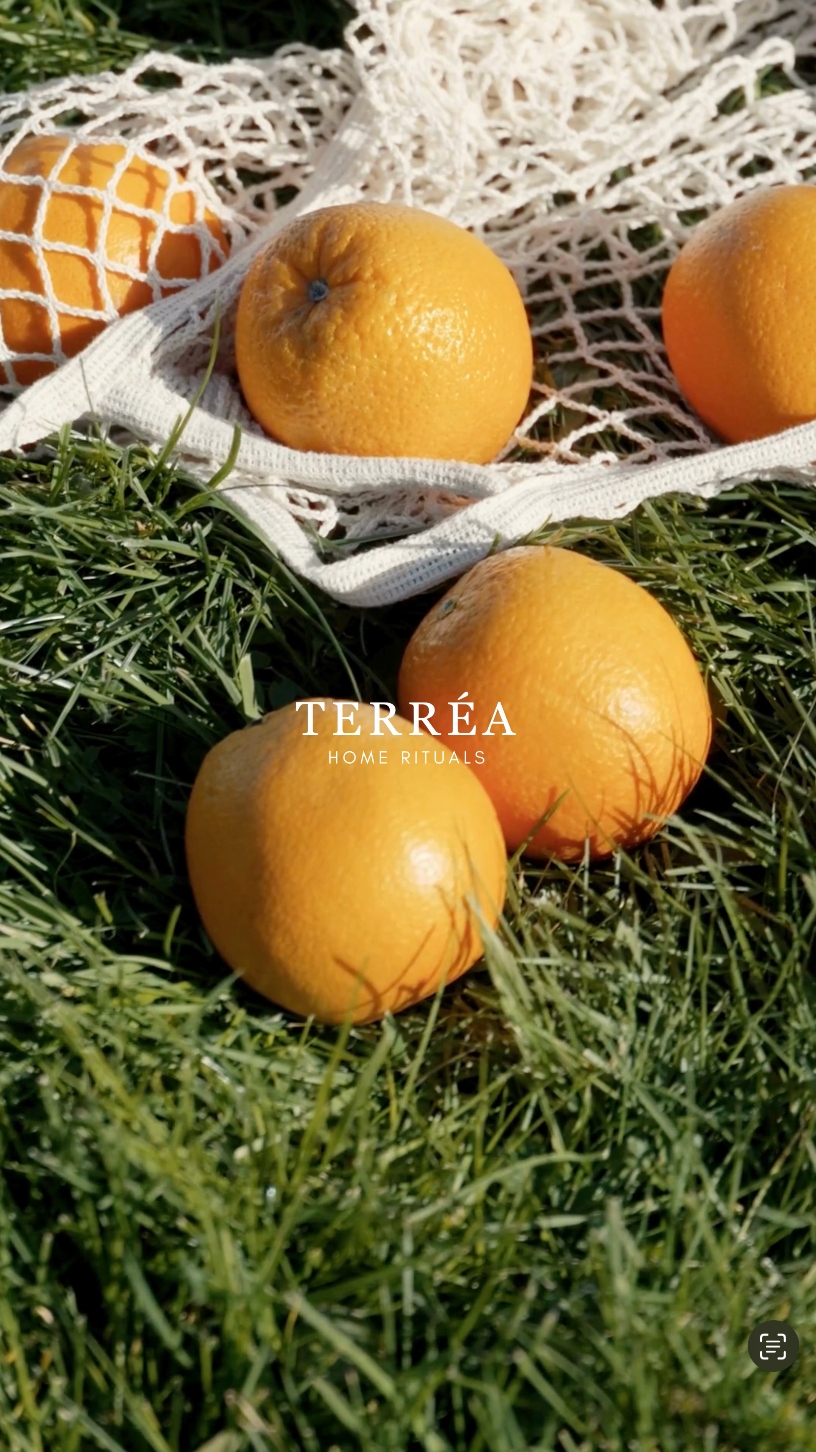 Fresh oranges in a reusable net bag on grass, spring styling for a sustainable guest room and home fragrance ritual