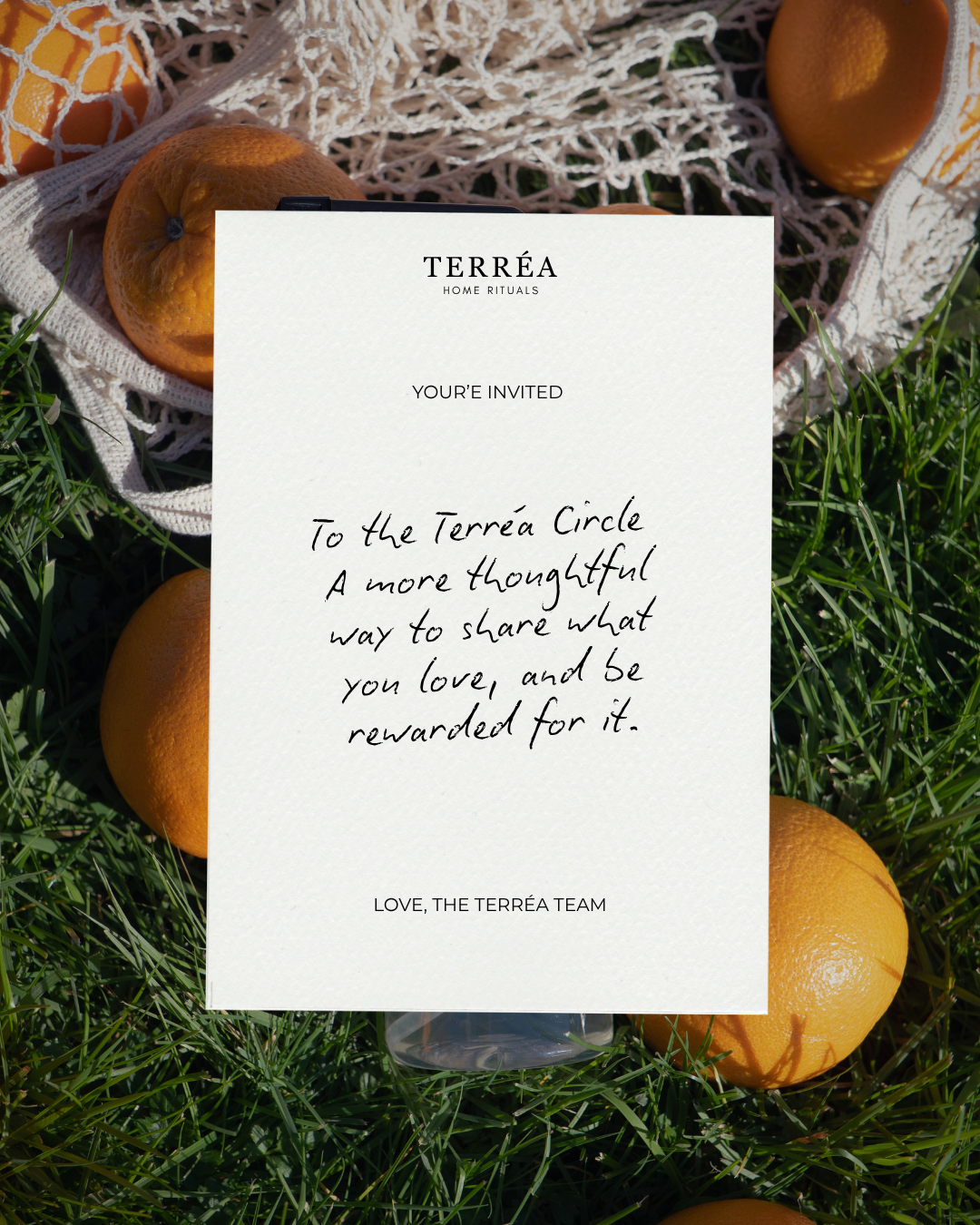 Terréa Home Rituals invitation card on grass with oranges, promoting sustainable luxury home care products