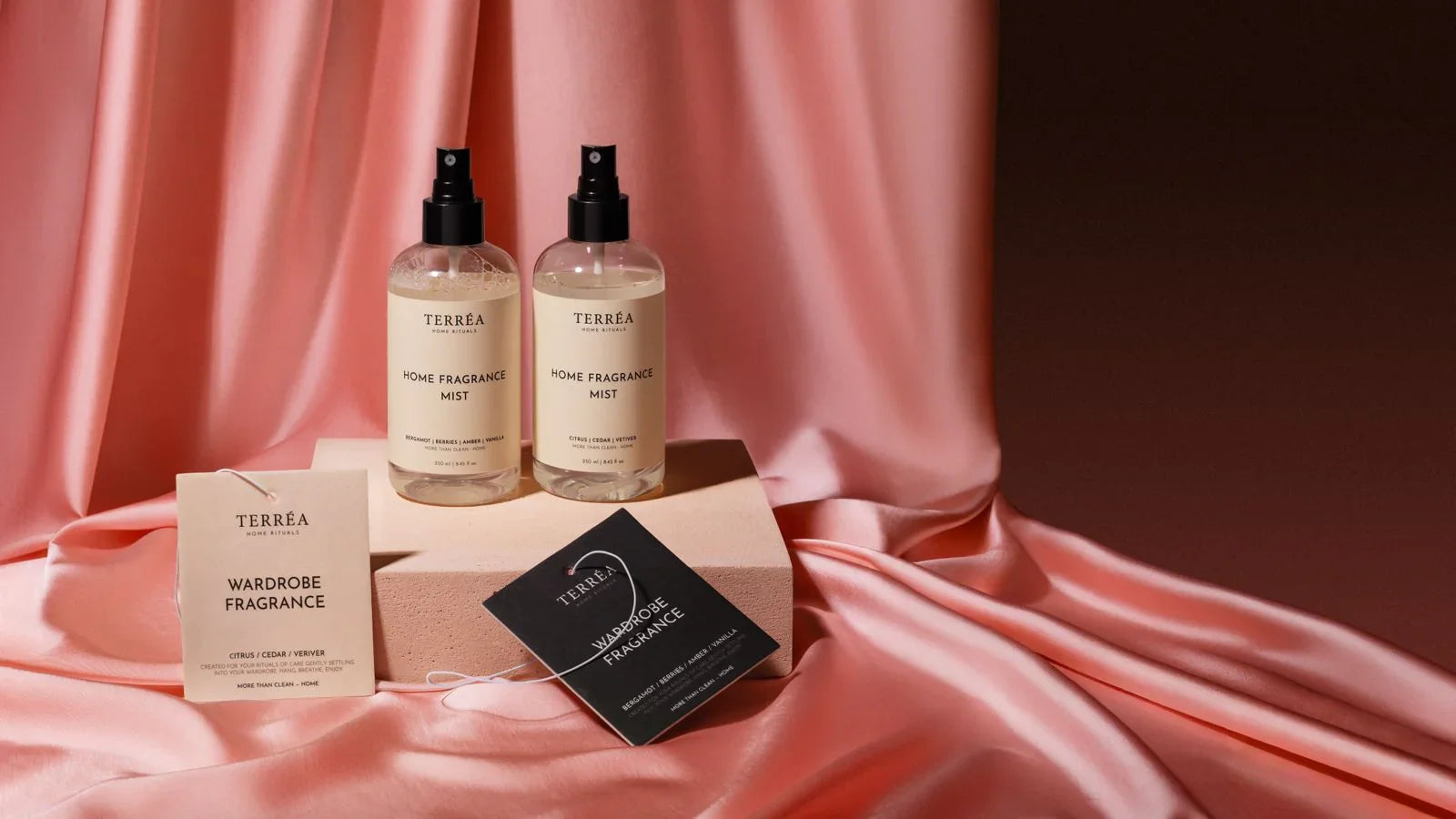 Two TERRÉA Home Fragrance Mist bottles with Wardrobe Fragrance tags on pink satin, eco-luxury home scents