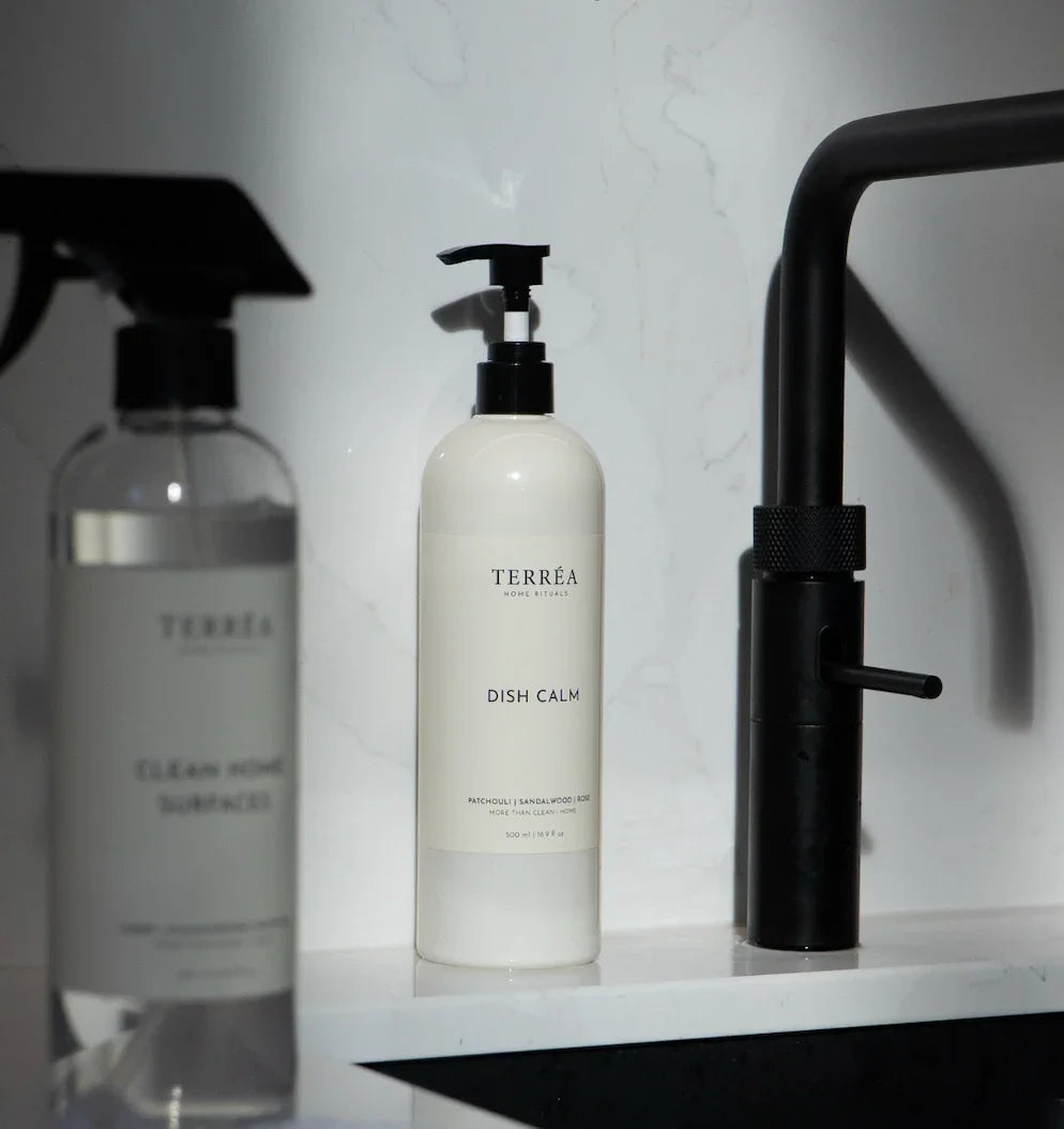 Eco-friendly dish soap 'Dish Calm' with pump dispenser on marble kitchen counter, sustainable home care