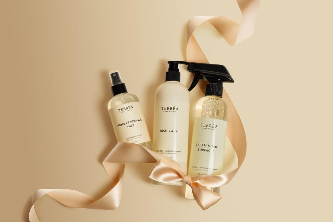 Three Terrea cleaning product bottles on a beige background with ribbons.