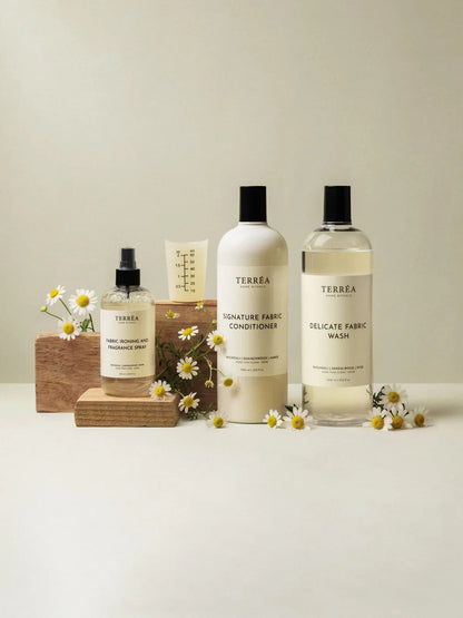 Terrea Home Rituals fabric care products with daisies, featuring conditioner, wash, and fragrance spray.