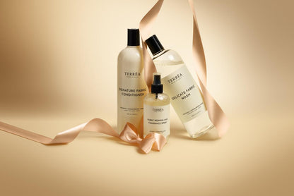 Three bottles of Terrea fabric care products on a beige background with ribbons.