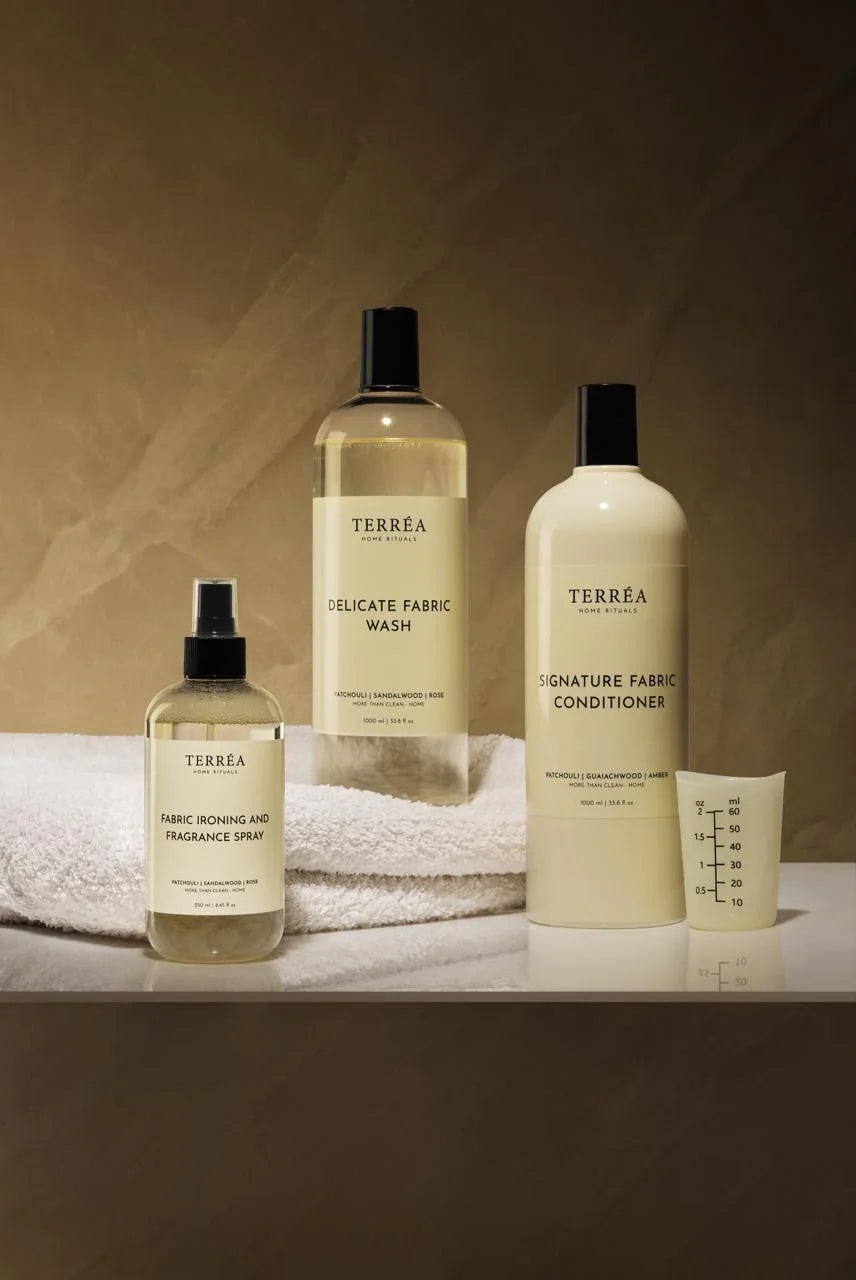 Set of Terrea fabric care products including a spray bottle, liquid soap, and conditioner on a neutral background.