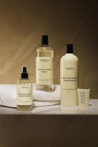 Set of Terrea fabric care products including a spray bottle, liquid soap, and conditioner on a neutral background.