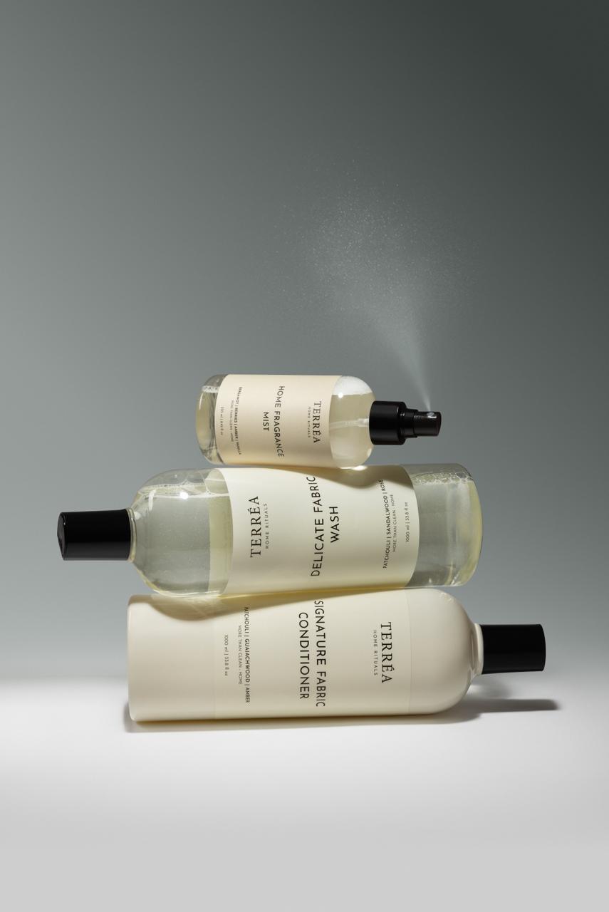 Three bottles of Teresia laundry products stacked on a gray background