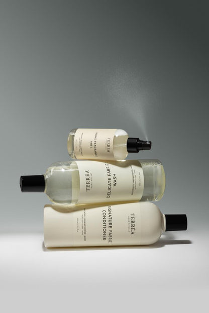 Three bottles of Teresia laundry products stacked on a gray background