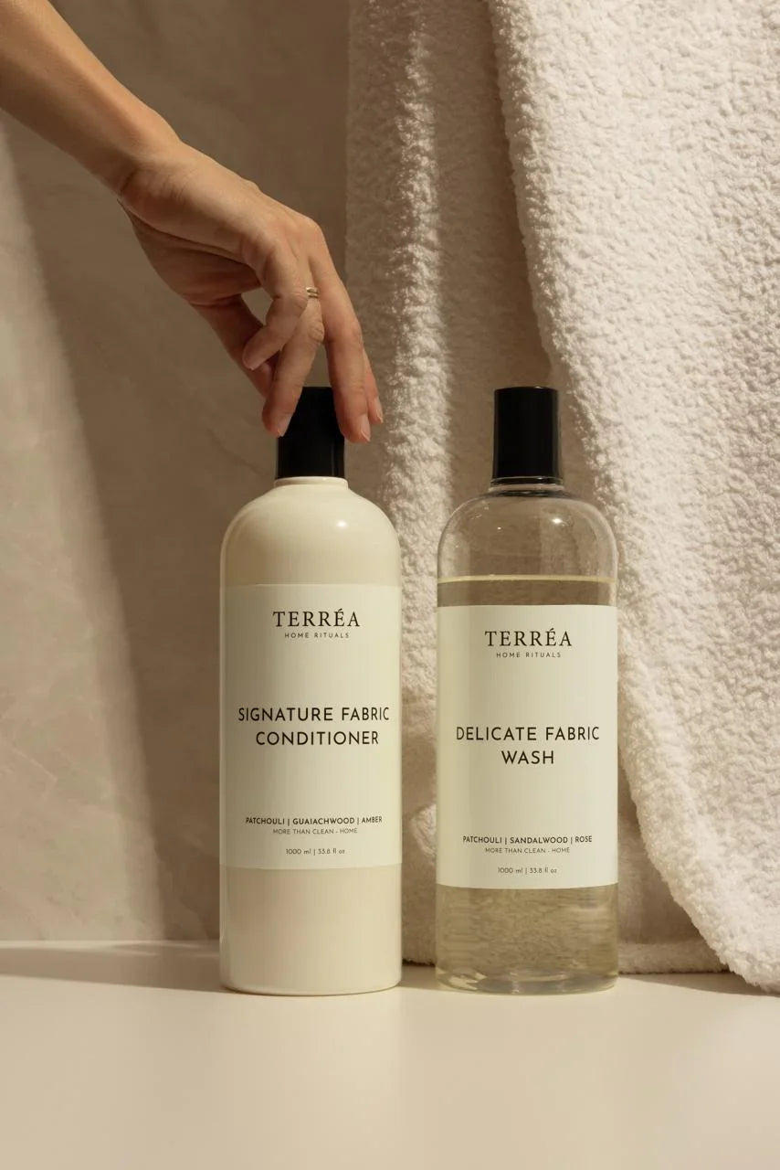 Two bottles of Terrea fabric care products on a neutral background