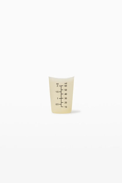Small beige measuring cup with black text on a white background