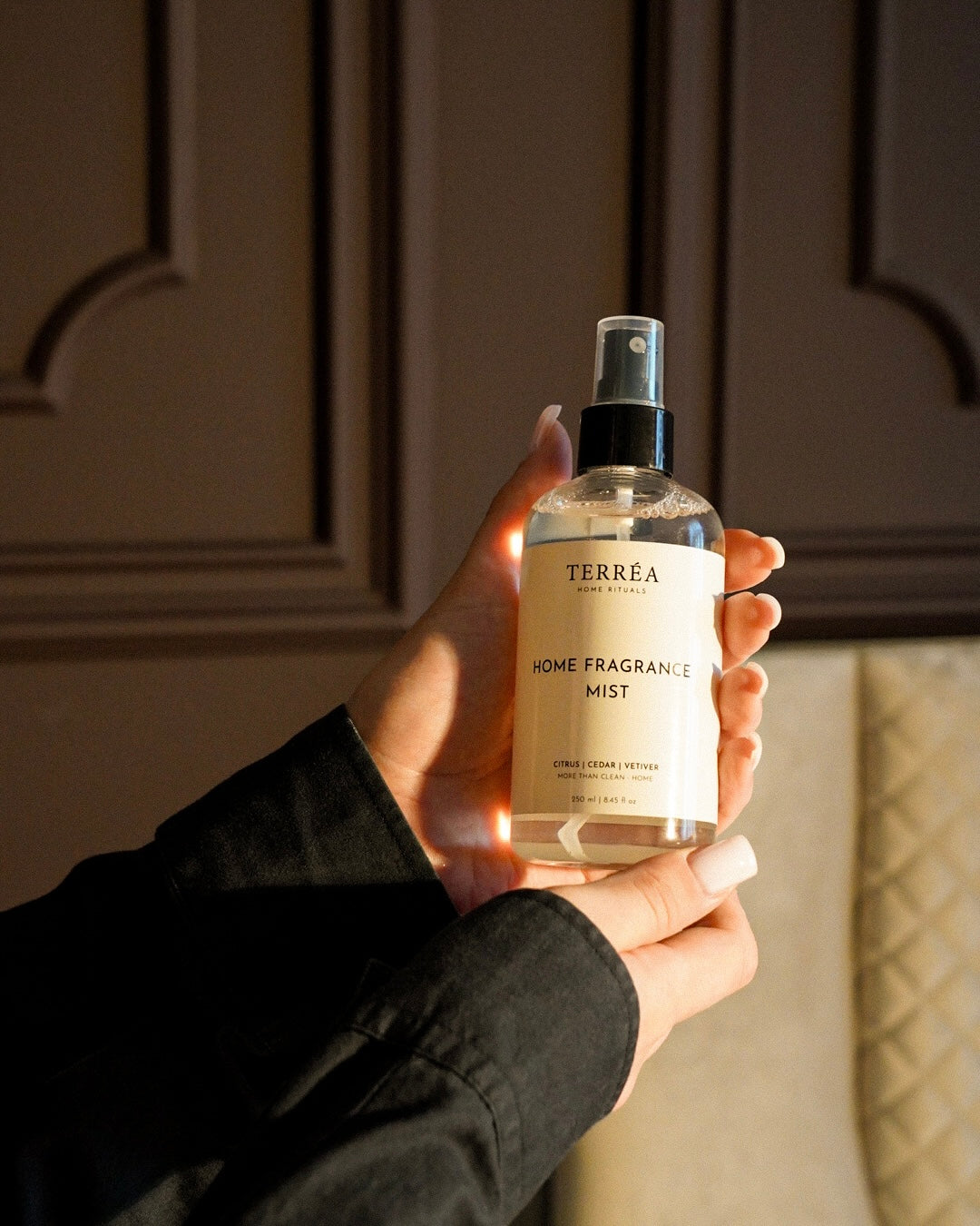 Terréa Home Fragrance Mist, 250 ml, Citrus / Cedar / Vetiver, held in the hand in evening light