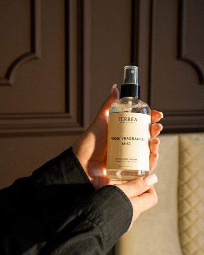 Terréa Home Fragrance Mist, 250 ml, Citrus / Cedar / Vetiver, held in the hand in evening light
