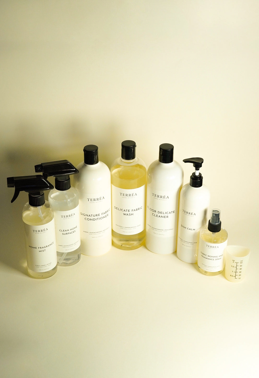 The Terréa home care range: surface spray, home fragrance mist, laundry, floor and kitchen bottles with a measuring cup