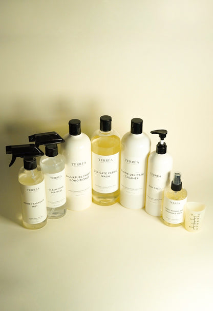 The Terréa home care range: surface spray, home fragrance mist, laundry, floor and kitchen bottles with a measuring cup